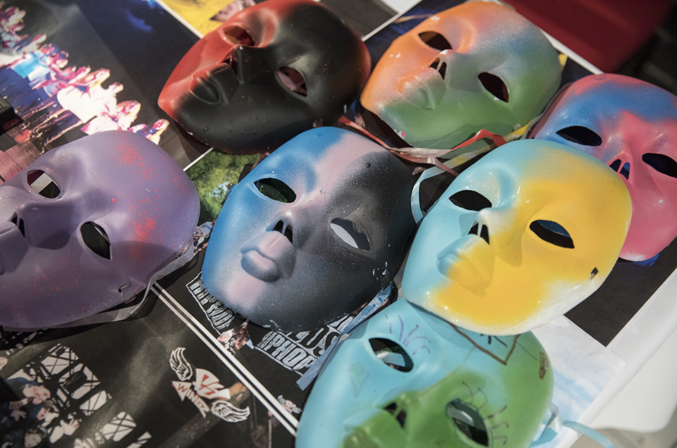 Colourful painted masks are laid out on a table