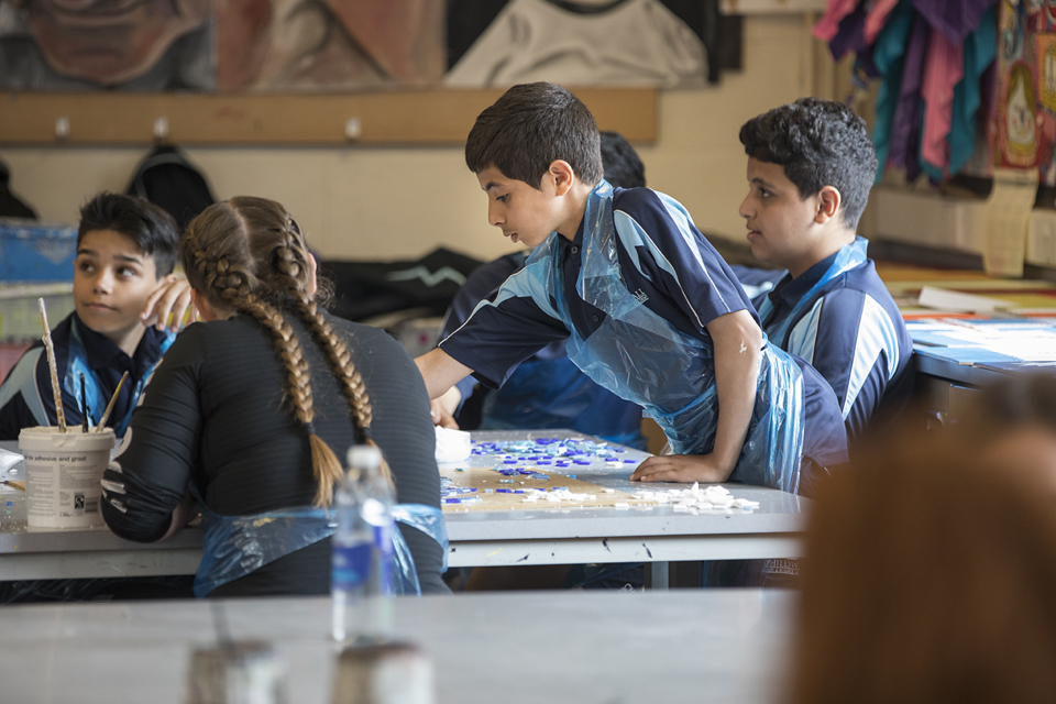 Children in an art classroom using materials.