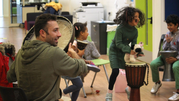 An artist engages young people with energetic percussion activities