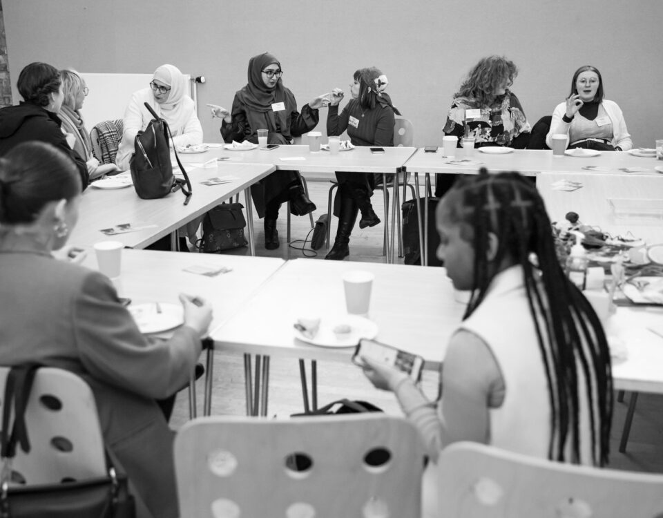 A group of young people engaged in conversations around a table.