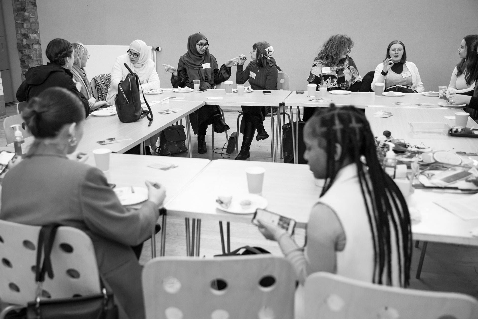 A group of young people engaged in conversations around a table.